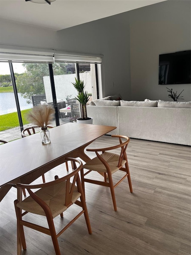 dining room featuring a water view and wood finished floors