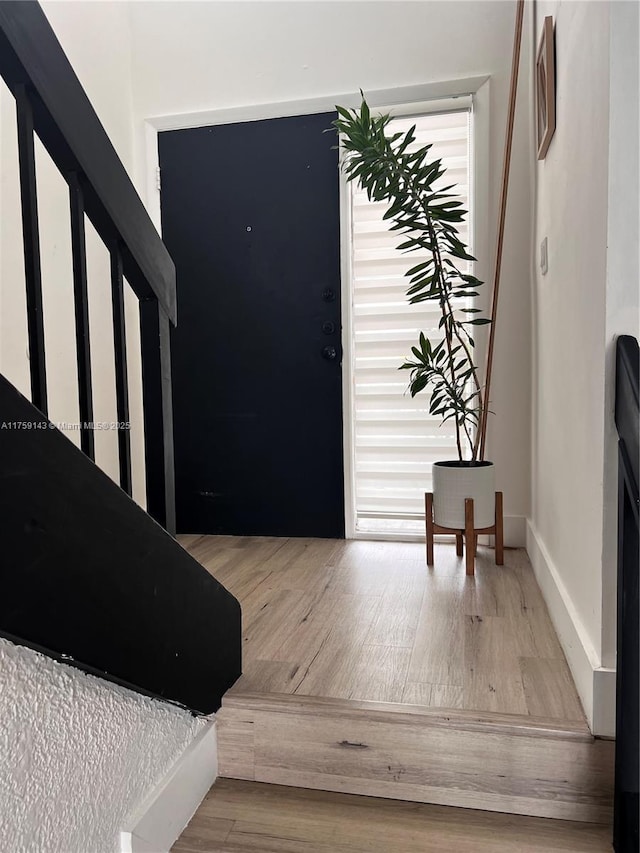 foyer with baseboards and wood finished floors