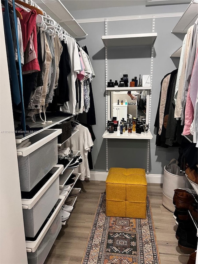 walk in closet with wood finished floors