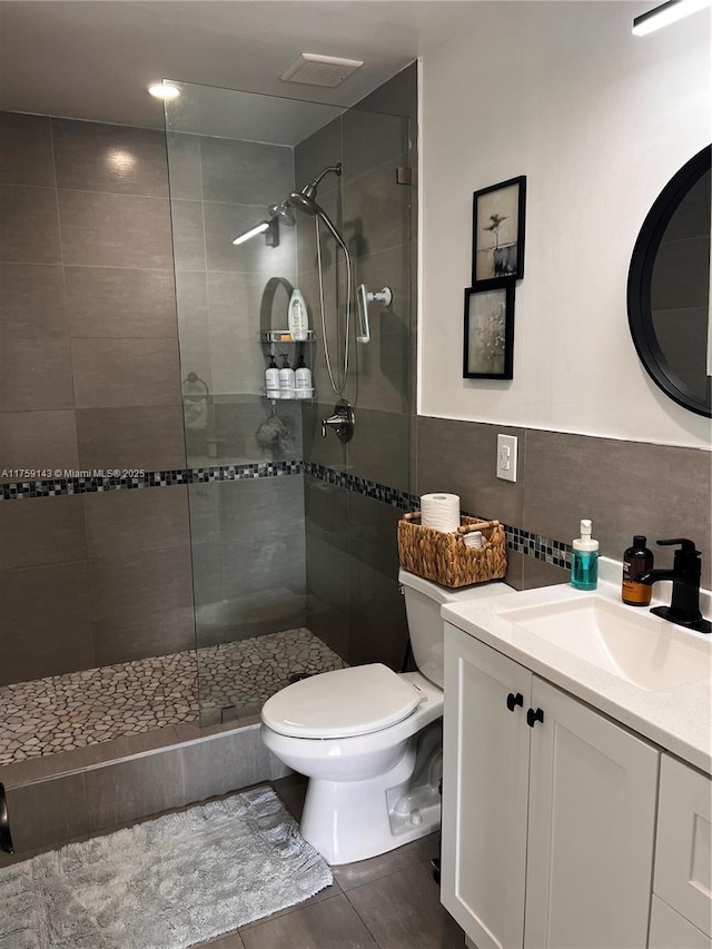 full bath with toilet, vanity, tile walls, a tile shower, and tasteful backsplash