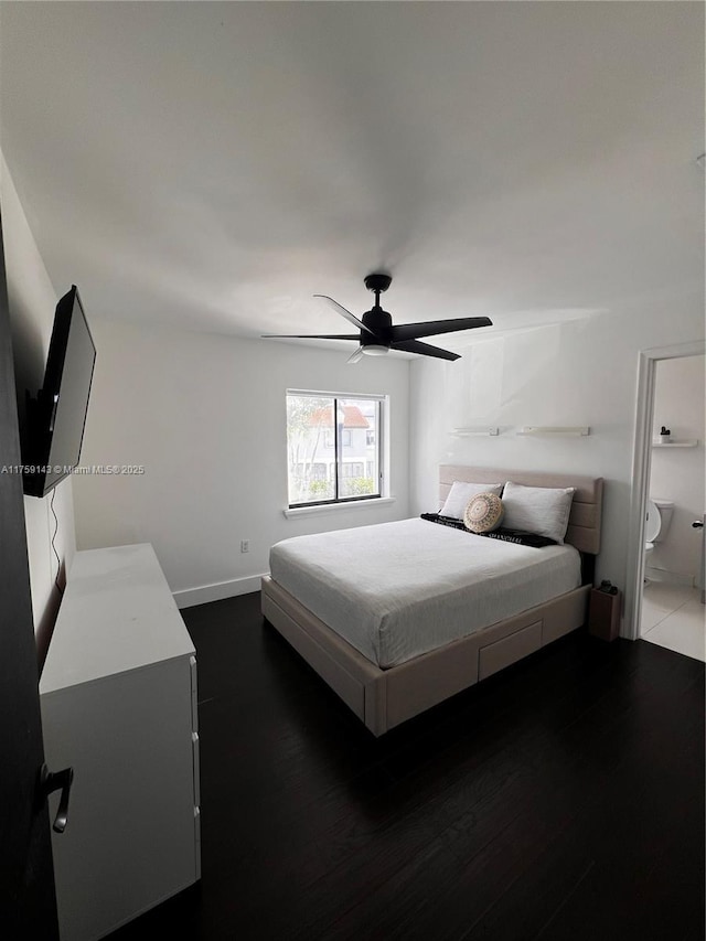 bedroom featuring connected bathroom, wood finished floors, a ceiling fan, and baseboards