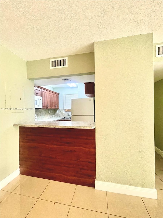 kitchen featuring light tile patterned flooring, visible vents, and white appliances