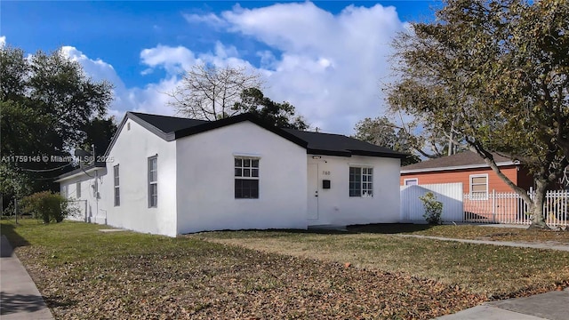 view of front of home featuring a front yard, fence, and stucco siding