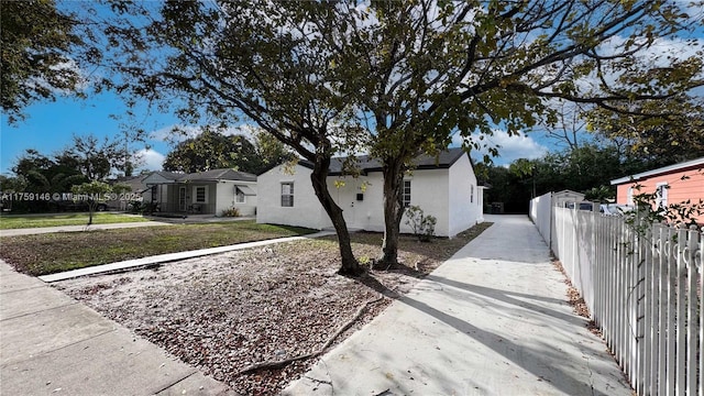 exterior space with stucco siding, a residential view, driveway, and fence