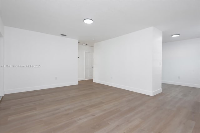 spare room with light wood finished floors and baseboards