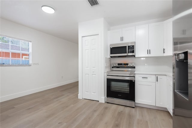 kitchen with visible vents, light wood-style flooring, stainless steel appliances, light countertops, and white cabinetry