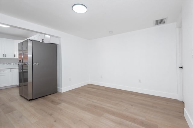 kitchen featuring visible vents, stainless steel fridge with ice dispenser, light countertops, light wood-style flooring, and white cabinetry
