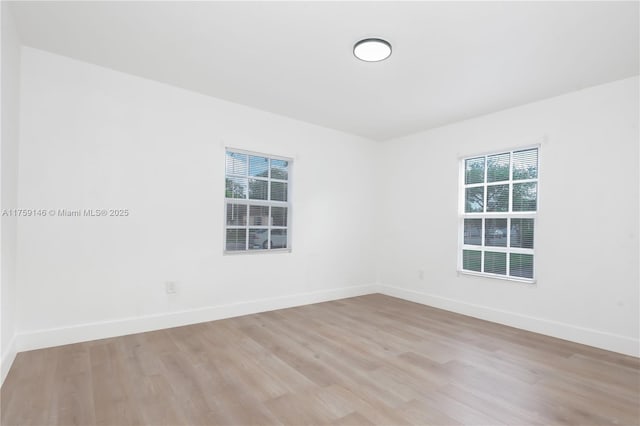 empty room featuring light wood finished floors and baseboards