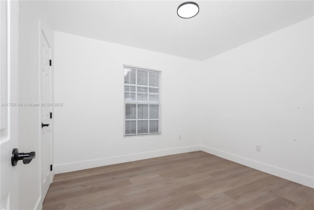 empty room featuring baseboards and light wood-style flooring