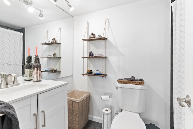 6770 Indian Creek Dr Unit 5K, Miami Beach, FL 33141 - bathroom with toilet, vanity, baseboards, and rail lighting