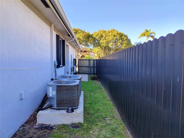 view of yard with central AC and a fenced backyard