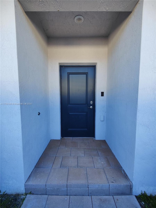 view of exterior entry featuring stucco siding