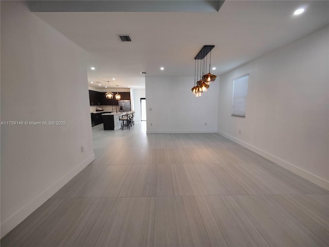 spare room with recessed lighting, visible vents, baseboards, and an inviting chandelier