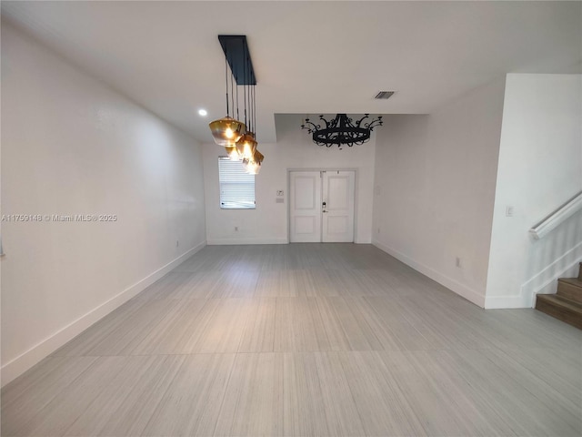 empty room with stairway, baseboards, and visible vents