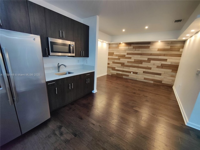 kitchen with visible vents, a sink, appliances with stainless steel finishes, light countertops, and dark wood-style flooring