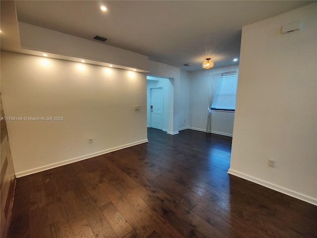 spare room with recessed lighting, visible vents, baseboards, and dark wood-style flooring