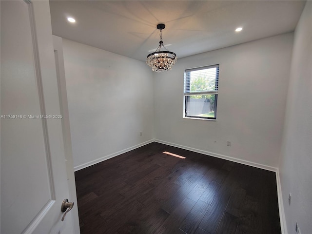 empty room with dark wood finished floors, a notable chandelier, recessed lighting, and baseboards