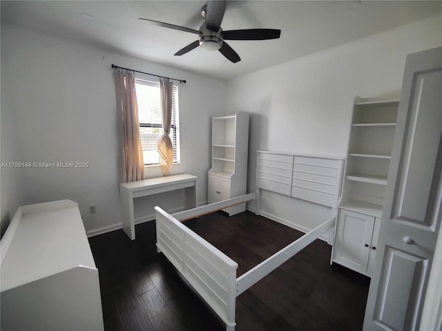 bedroom with ceiling fan, dark wood-type flooring, and baseboards