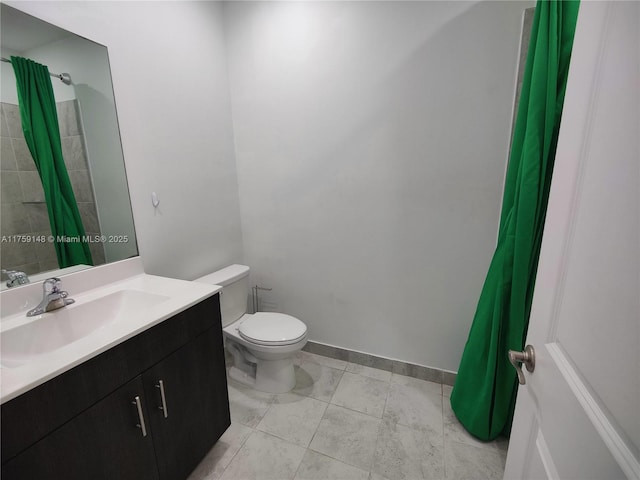 bathroom with toilet, vanity, and baseboards