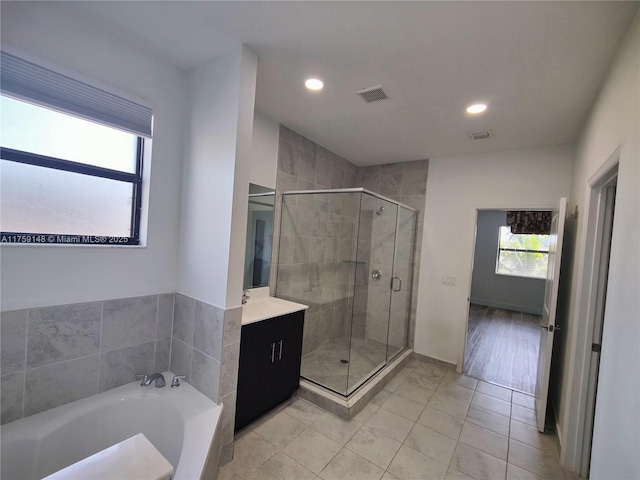 bathroom featuring visible vents, a shower stall, vanity, and a garden tub