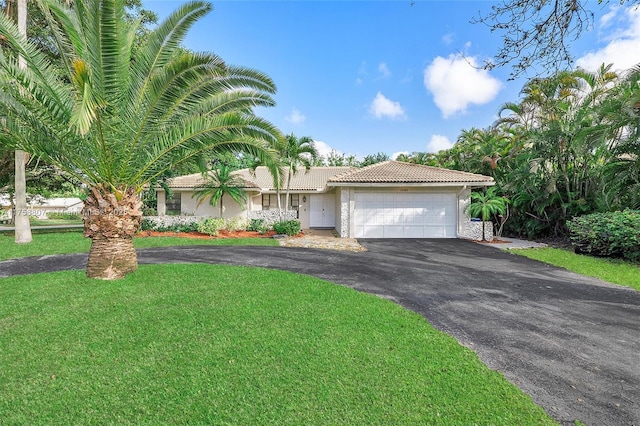 ranch-style home with aphalt driveway, a tiled roof, an attached garage, a front yard, and stucco siding