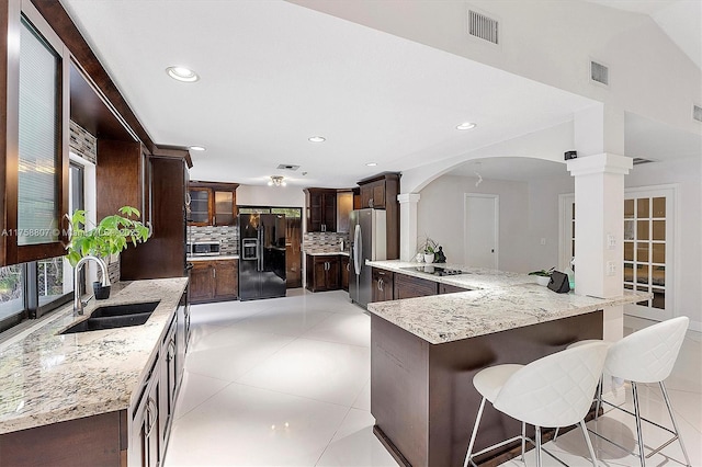 kitchen featuring visible vents, decorative backsplash, a sink, dark brown cabinets, and black appliances