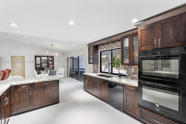 kitchen with lofted ceiling, dark brown cabinetry, a sink, black appliances, and tasteful backsplash