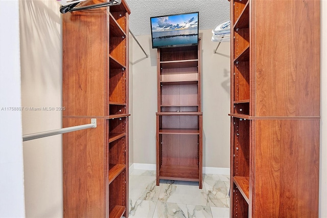 spacious closet featuring marble finish floor