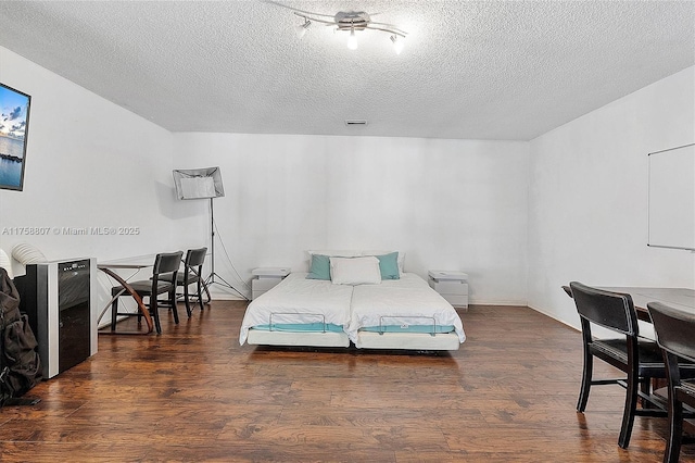 bedroom with a textured ceiling and wood finished floors