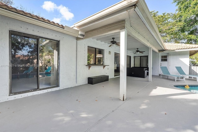 view of patio with a ceiling fan and an outdoor pool