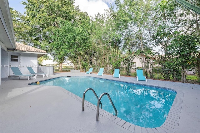 view of swimming pool with a patio, fence, and a fenced in pool