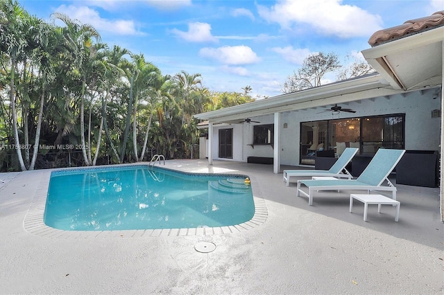 outdoor pool with ceiling fan, outdoor lounge area, and a patio