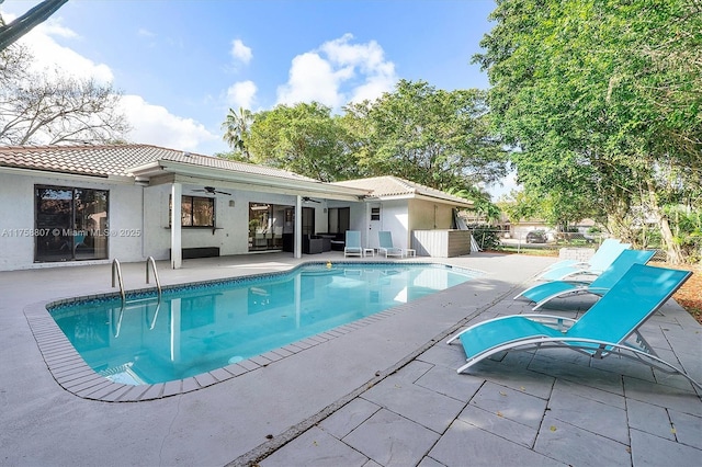 outdoor pool with ceiling fan, a patio, and fence