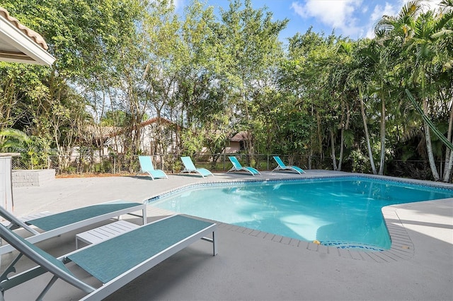 view of swimming pool featuring a patio area, fence, and a fenced in pool