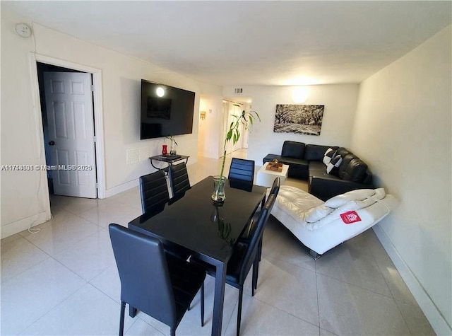 dining space featuring light tile patterned flooring and baseboards