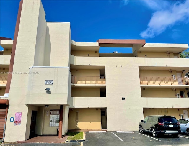 view of building exterior with uncovered parking