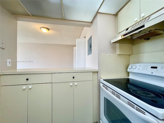 kitchen featuring a textured ceiling, light countertops, under cabinet range hood, and white range with electric cooktop