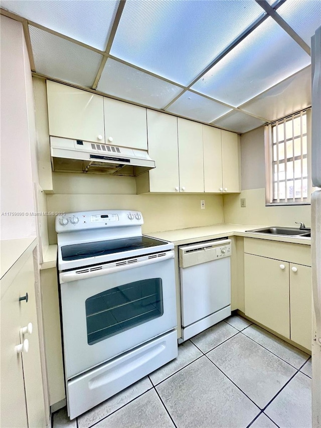 kitchen with under cabinet range hood, white appliances, light tile patterned floors, and light countertops