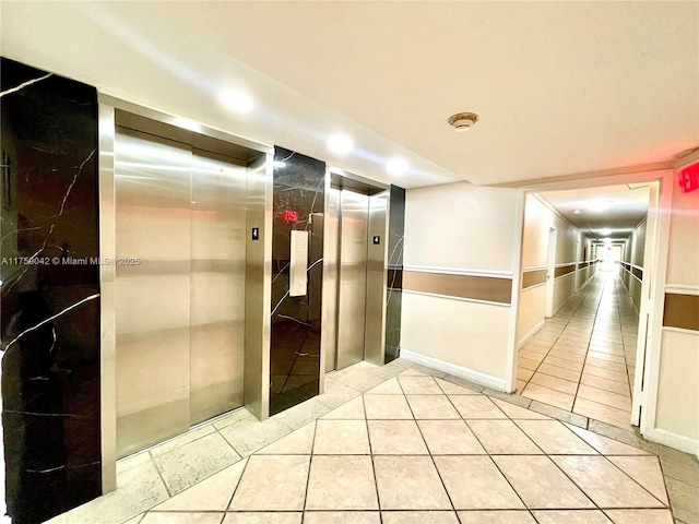 hall with light tile patterned floors and elevator