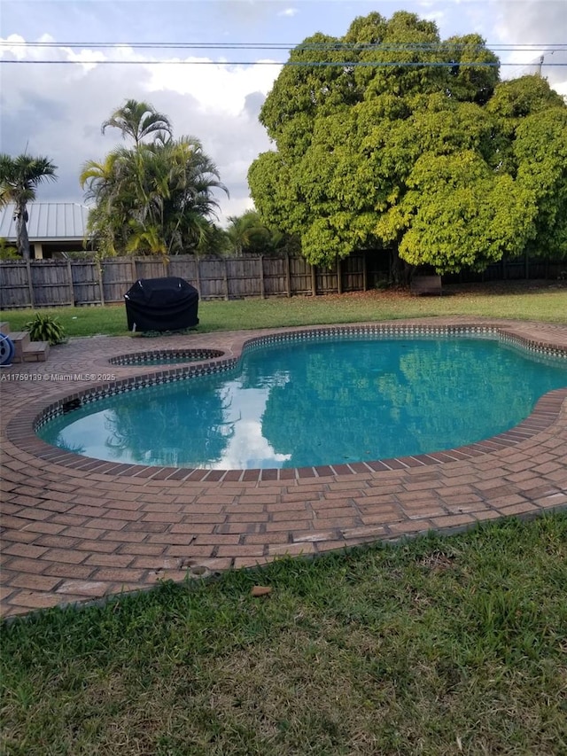 view of pool with a fenced in pool, a yard, grilling area, a patio area, and a fenced backyard