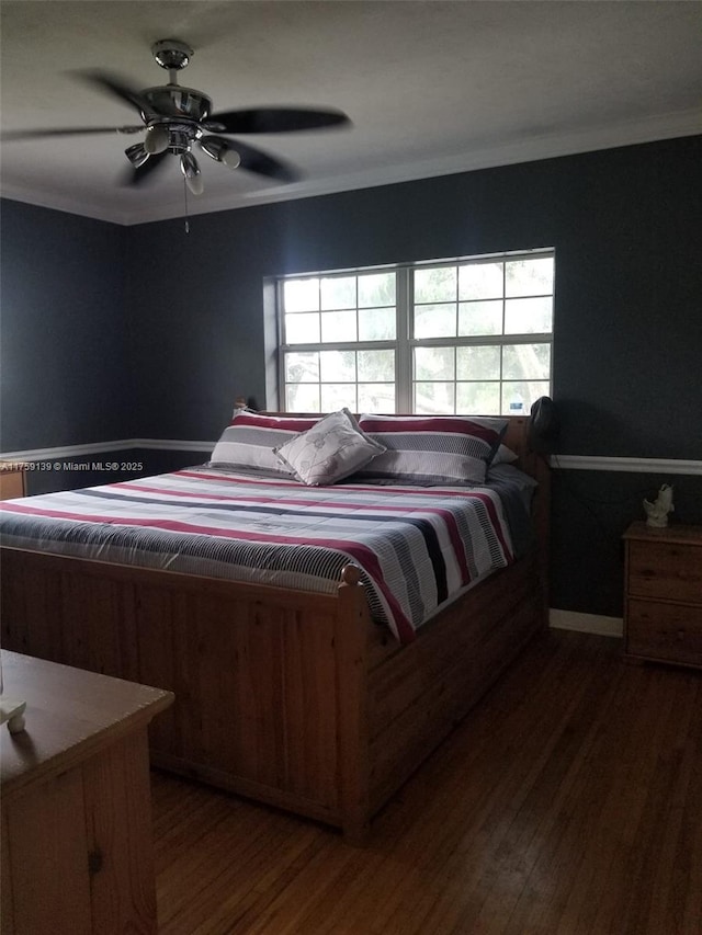 bedroom with ornamental molding, wood finished floors, and a ceiling fan