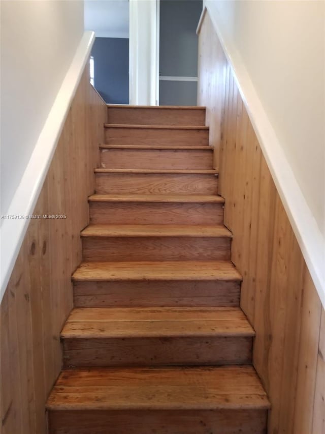 staircase with wood walls