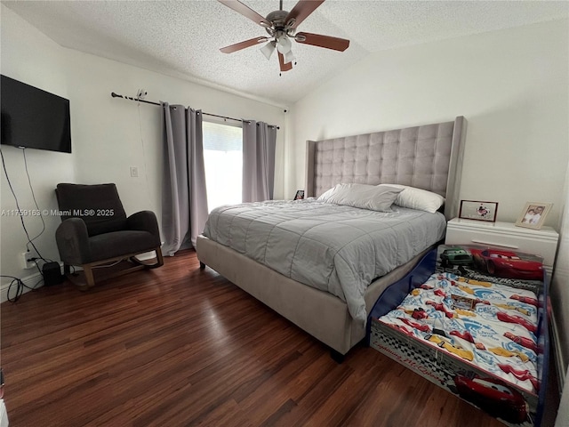 bedroom featuring ceiling fan, vaulted ceiling, wood finished floors, and a textured ceiling