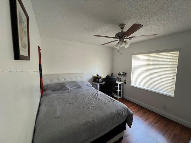 bedroom with ceiling fan, baseboards, and a textured ceiling
