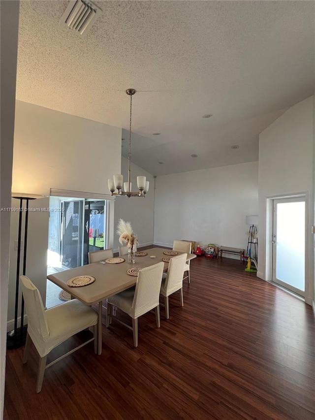 dining area featuring vaulted ceiling, wood finished floors, visible vents, and a notable chandelier