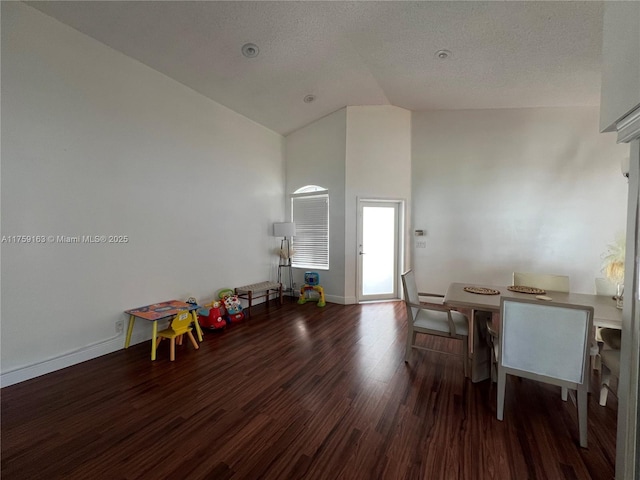 game room featuring high vaulted ceiling, baseboards, wood finished floors, and a textured ceiling