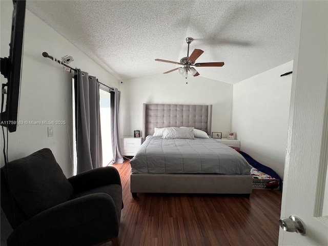 bedroom with dark wood-style floors, a textured ceiling, lofted ceiling, and a ceiling fan