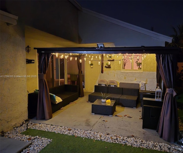 patio at night featuring an outdoor living space