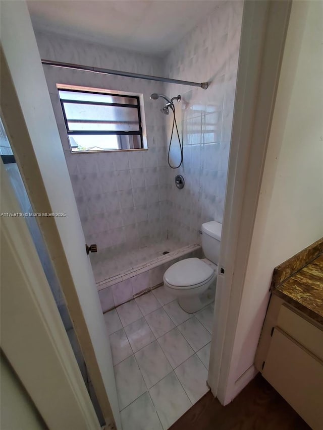 bathroom with a stall shower, vanity, toilet, and tile patterned floors