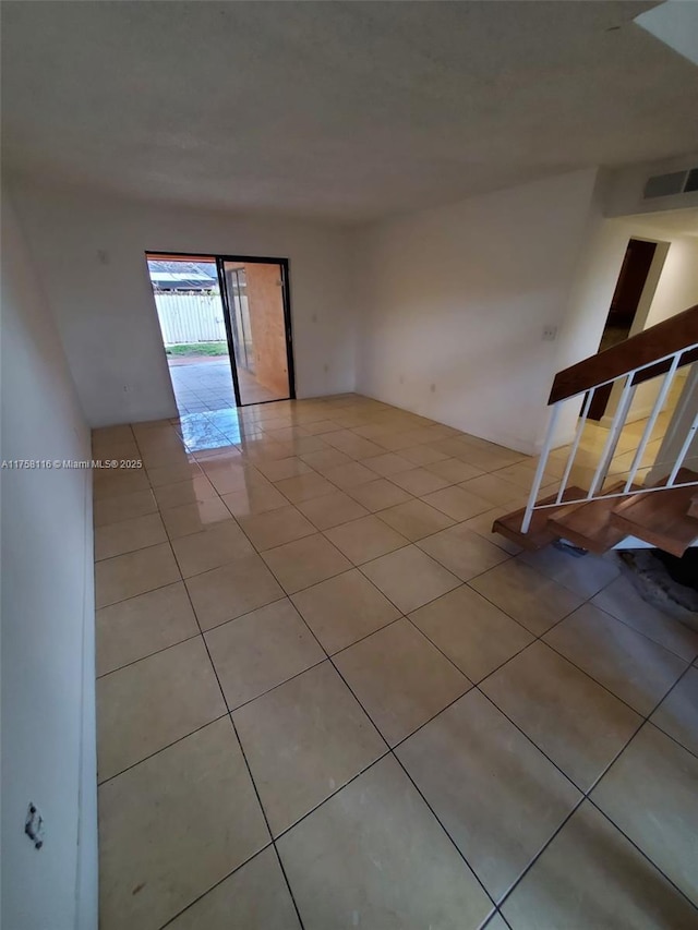 empty room with light tile patterned floors and visible vents